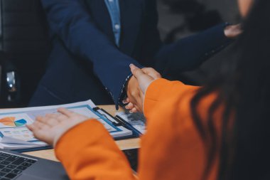 Ofis toplantısında iki farklı profesyonel iş adamı yönetici lider el sıkışıyor.