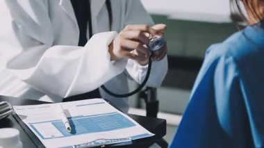 Doktor kadın hastayı tutuyor ve doktorla konuşuyor..