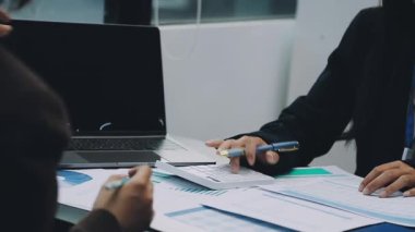 Takım elbiseli iş kadını oturuyor ve iş planını tartışıyor.