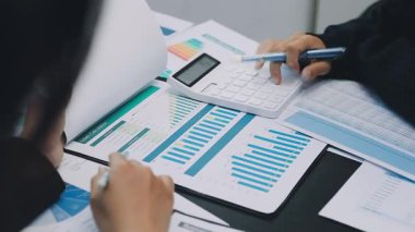 İş adamı dizüstü bilgisayarındaki finansal belgelerle çizelgeleri analiz ediyor.