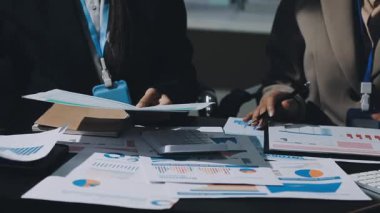 Finansal tablolar ve tabletlerle grafiği analiz eden işadamı