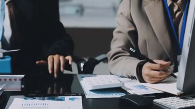 Yakın çekim. Bir grup iş adamı ofiste mali verileri tartışıyor.