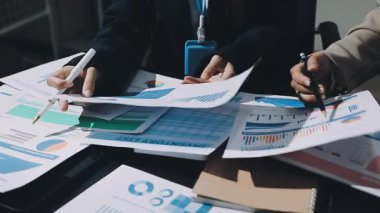 Yakın plan - bir iş adamının elinde bir belge tutarken ve ofisteki bir iş raporuna işaret ederken