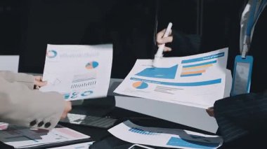 İş ekibi masadaki dizüstü bilgisayarda mali istatistikleri tartışıyor.
