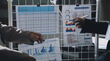 İş kadını elinde dosya ve grafiklerle bir pano tutuyor.