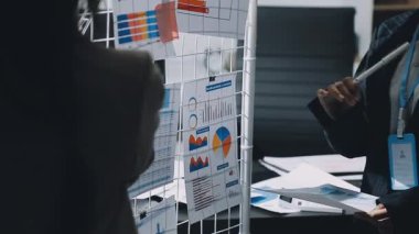 İş adamları ofiste grafikleri tartışıyor ve analiz ediyorlar.
