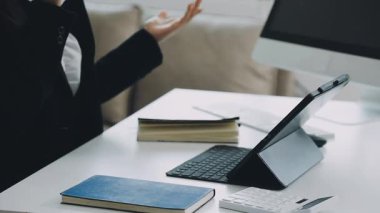 Ofiste dizüstü bilgisayar ve tabletle çalışan kadın.