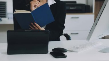 İş kadını ofiste bilgisayar ve belgelerle çalışıyor.