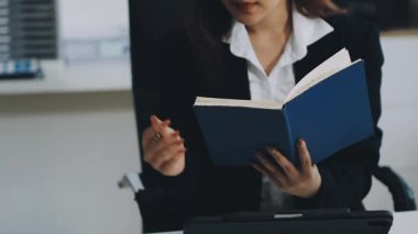 young woman reading book in the office