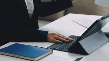 Masada dizüstü bilgisayar ve defterle çalışan iş kadını.