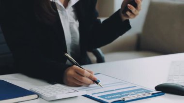 İş kadını ofisteki bir deftere yazı yazıyor.