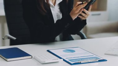 Genç bayan girişimci ofisinde dijital tablet üzerinde çalışıyor.