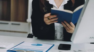 Modern bir ofiste dizüstü bilgisayarla çalışan genç bir kadın..