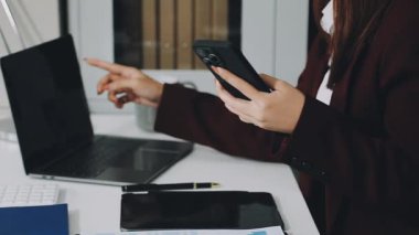 Kadın cep telefonu tutuyor ve ofiste çalışıyor, iş konsepti