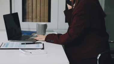 İş kadını elinde bir tablet tutuyor ve ofisteki masada daktilo yazıyor. iş ve teknoloji