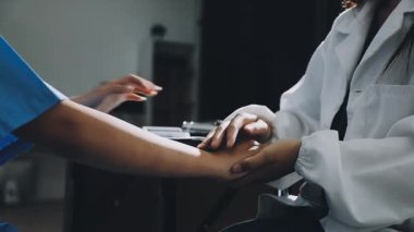 Asyalı doktor hasta klinikte el ele tutuşuyor..