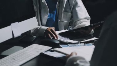 Doktor bilgisayar kullanıyor ve klinikte tıbbi raporlarla çalışıyor. Sağlık ve Sağlık Hizmetleri.