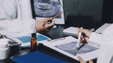 Ofisteki doktor. Doktor elinde bir kalem ve yazı tutuyor..