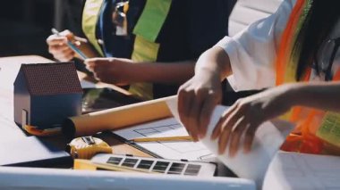 İnşaat endüstrisinin planı üzerinde çalışan işçilere yakın çekim