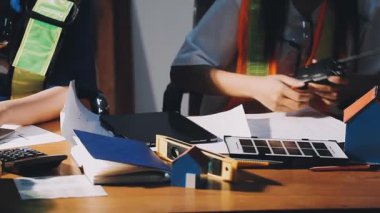 Siyah takım elbiseli mühendis veya mimar. Ofis, inşaat ve mühendislik konseptindeki planlar ve planlar üzerinde çalışıyorlar..