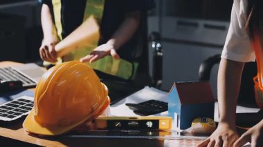 İşyerinde dizüstü bilgisayarla çalışan mühendis, mimar ya da mimar, inşaat alanında BlueBell, mühendislik ve inşaat konseptinde çalışan