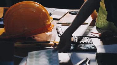 Bilgisayarı ve akıllı telefonu olan inşaat işçisi.