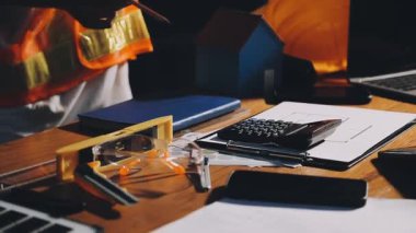 Masada dizüstü bilgisayar ve defterle çalışan kadın.