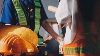 Kasklı ve kasklı mühendis. Üzerinde plan var..