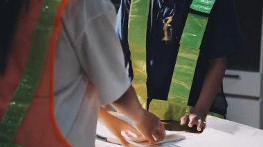 Kütüphanede kitap ve mezuniyet şapkası takan Asyalı genç kız.