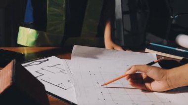 Birlikte çalışırken genç bir kadının el ele tutuşup belgelere bakması.