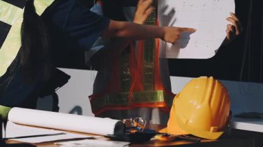 İnşaat alanındaki planlar üzerinde çalışan genç mühendis.