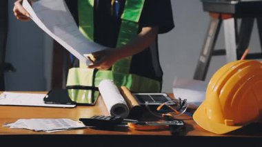 İş yerindeki planlar üzerinde çalışan mühendis.