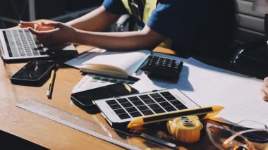 İnşaat alanında planlar ve dizüstü bilgisayar üzerinde çalışan sarı başlıklı mühendis. inşaat mühendisliği kavramı.