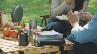 Genç adam dizüstü bilgisayarıyla parkta oturuyor..