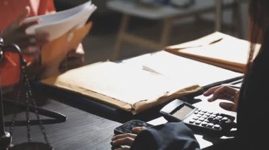 İş adamı hesap makinesi kullanıyor ve belgeler üzerinde çalışıyor