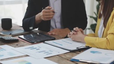 İş kadını finansal grafiği analiz etmek ve masadaki dizüstü bilgisayardaki verileri analiz etmek için hesap makinesi kullanıyor.