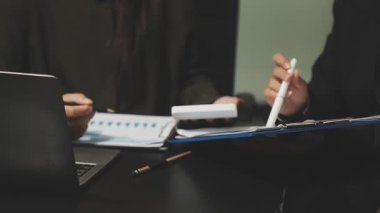 Ofiste hesap makinesi olan bir iş adamı var.