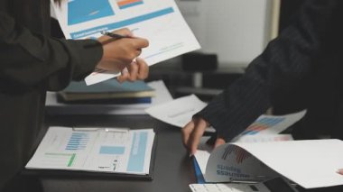 Bir bilgisayar üzerinde grafikler ve çizelgeler ile ofiste çalışan iş ekibi.