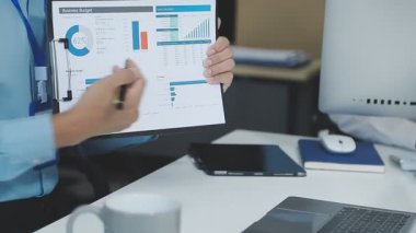 İş kadını ofisteki dizüstü bilgisayardaki grafiği analiz ediyor