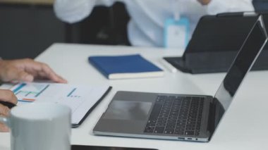 İş adamları modern ofis masasında birlikte çalışırlar.