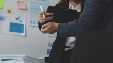 İşadamı elinde kalemle bir tablet tutuyor..