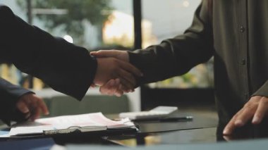 İş adamı, modern iç mekanda ortağıyla el sıkışıyor..