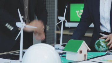 İş kadını ve yeşil ev modeli olan bir adam.