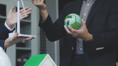 Ofiste yeşil küreyi tutan iş adamları.