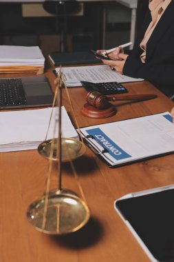 Attractive young lawyer in office Business woman and lawyers discussing contract papers with brass scale on wooden desk in office. Law, legal services, advice, Justice and real estate concept.