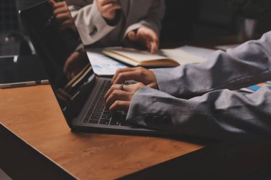 Group of confident business people point to graphs and charts to analyze market data, balance sheet, account, net profit to plan new sales strategies to increase production capacity.