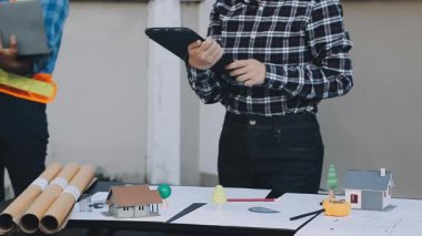 Tablet ve bilgisayarla inşaat alanında çalışan mühendis.