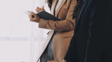 Belgeleri tutan ve ofiste tablet üzerinde çalışan bir iş kadını. iş kavramı