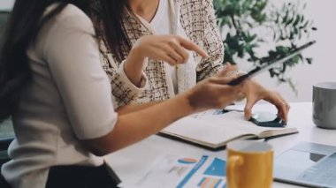 Meslektaşıyla birlikte tablet bilgisayar kullanan bir iş kadını..