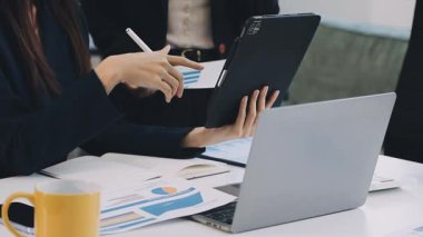 Ofiste bilgisayar ve akıllı telefon kullanan bir iş kadını.